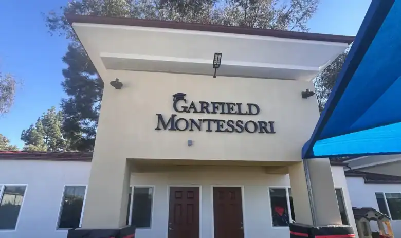 Close up view of black dimensional building letters on a textured stucco exterior for a business in North County San Diego.