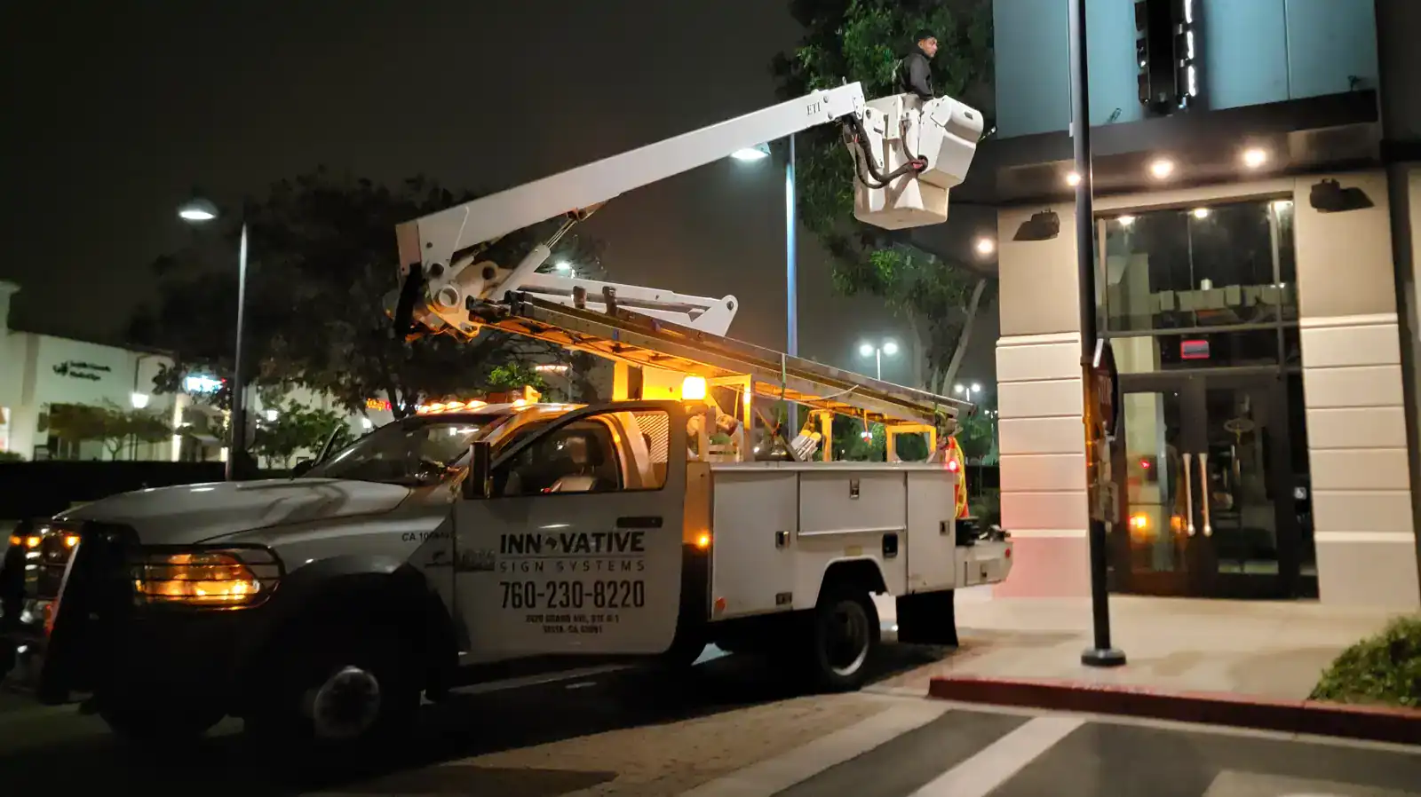 Innovative Sign Systems service truck with ETI bucket lift performing night installation in San Diego, acting as a trusted local partner for the largest sign companies in the US.